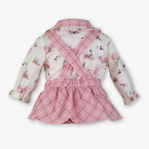A baby girl's two-piece outfit featuring a long-sleeve collared shirt with a pink and white winter forest print, paired with matching pink plaid overalls with crisscross straps.