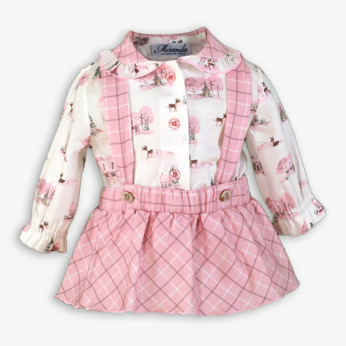 A baby girl's long-sleeve dress with a white and pink winter print on the top and a pink plaid skirt, shown on a light gray background.