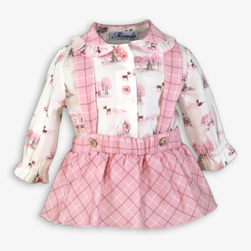 A baby girl's long-sleeve dress with a white and pink winter print on the top and a pink plaid skirt, shown on a light gray background.